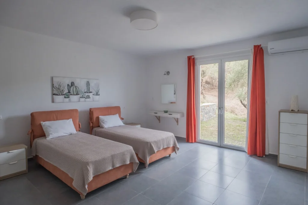 Guest bedroom with twin beds at Aegean Breeze Villa and outdoor view